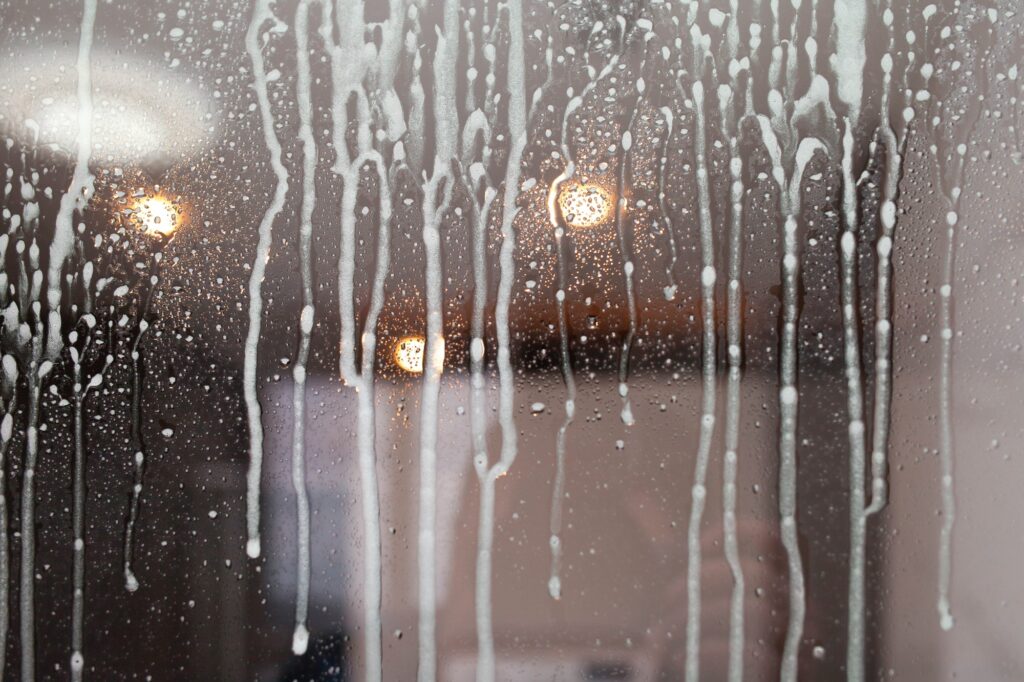 Drops of detergent for glass on the window